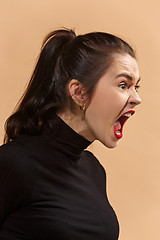 Image showing The young emotional angry woman screaming on pastel studio background