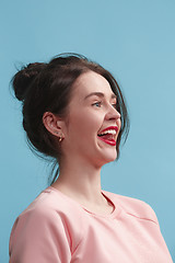 Image showing The happy business woman standing and smiling against blue background.