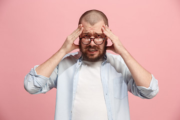 Image showing Man having headache. Isolated over pink background.