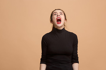 Image showing The young emotional angry woman screaming on pastel studio background