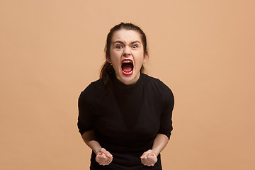 Image showing The young emotional angry woman screaming on pastel studio background