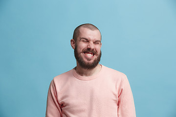 Image showing The happy business man standing and smiling against blue background.