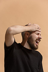 Image showing Man having headache. Isolated over pastel background.