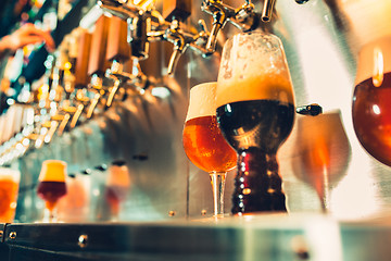 Image showing Hand of bartender pouring a large lager beer in tap.