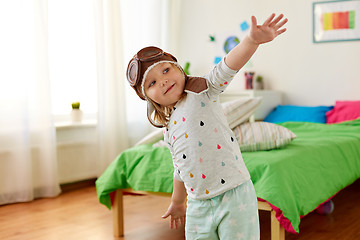 Image showing happy little girl in pilot hat playing at home