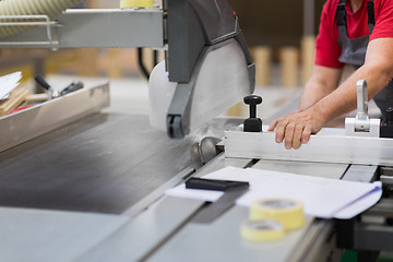 Image showing carpenter with panel saw and fibreboard at factory