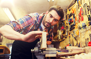 Image showing carpenter working with plane and wood at workshop