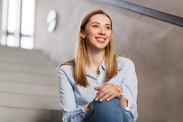 Image showing happy smiling woman or student sitting on stairs