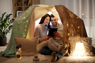 Image showing happy couple with tablet pc in kids tent at home