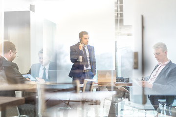 Image showing Businessman talking on a mobile phone on corporate office.