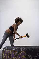 Image showing black woman workout with hammer and tractor tire