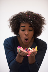 Image showing African American woman blowing confetti in the air