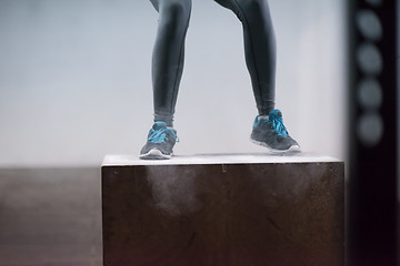 Image showing black woman is performing box jumps at gym