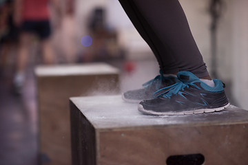 Image showing black woman is performing box jumps at gym