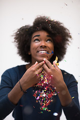 Image showing African American woman blowing confetti in the air