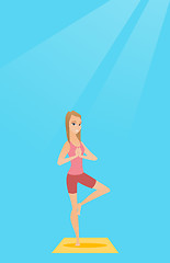 Image showing Young woman practicing yoga tree pose.