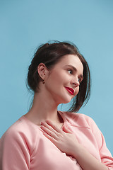 Image showing The happy business woman standing and smiling against blue background.