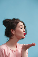 Image showing Portrait of attractive cute girl with bright makeup with kiss isolated over blue background