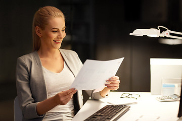 Image showing businesswoman with papers working at night office