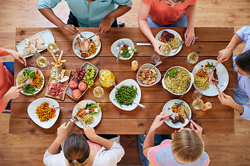 Image showing group of people eating at table with food