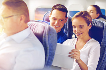 Image showing happy passengers with coffee talking in plane