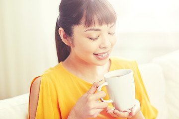 Image showing happy asian woman drinking from tea cup