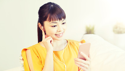 Image showing happy asian woman with smartphone and earphones