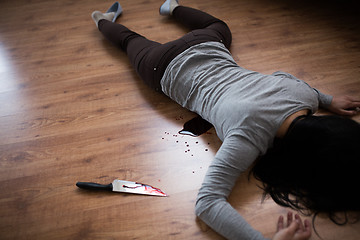 Image showing dead woman body lying on floor at crime scene