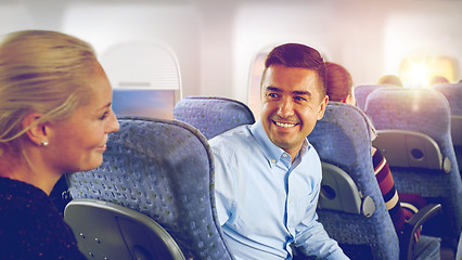 Image showing happy passengers talking in plane