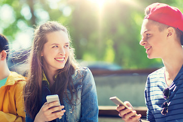 Image showing happy teenage friends with smartphones outdoors