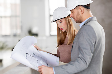 Image showing architects with blueprint and helmets at office