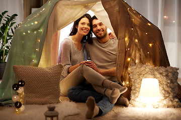 Image showing happy couple in kids tent at home