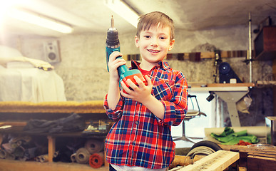 Image showing happy little boy with drill at workshop