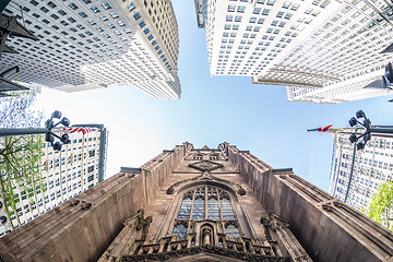 Image showing Wide angle upward view of Trinity Church at Broadway and Wall Street with surrounding skyscrapers, Lower Manhattan, New York City, USA