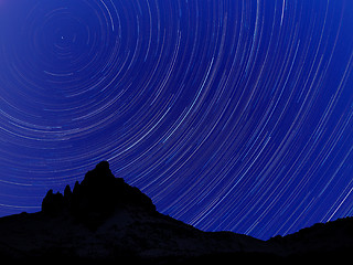 Image showing Long exposure image showing Night sky star trails over mountains