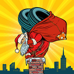 Image showing car winter tires. Santa Claus with gifts climbs into the chimney