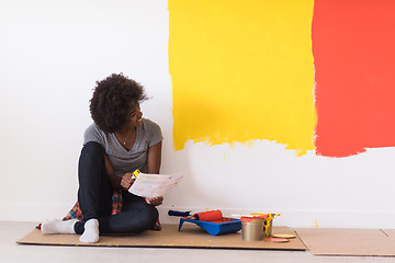 Image showing back female painter sitting on floor