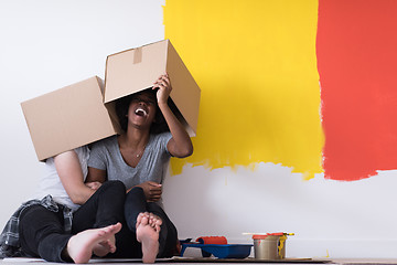 Image showing young multiethnic couple playing with cardboard boxes