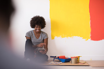 Image showing back female painter sitting on floor