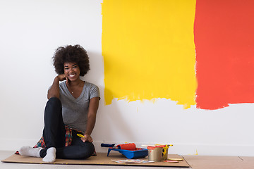 Image showing back female painter sitting on floor