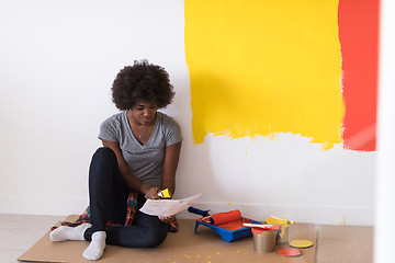 Image showing back female painter sitting on floor