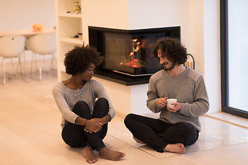 Image showing multiethnic couple  in front of fireplace