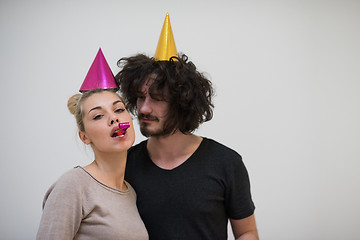 Image showing couple in party hats blowing in whistle