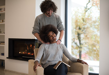 Image showing multiethnic couple hugging in front of fireplace