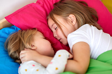 Image showing happy little girls sleeping in bed at home