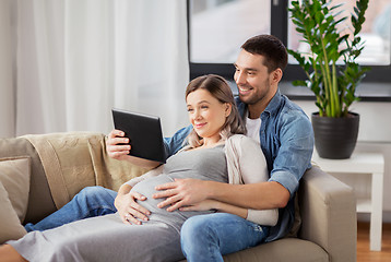 Image showing man and pregnant woman with tablet pc at home