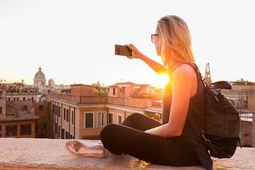 Image showing Female tourist taking mobile phone photo of Piazza di Spagna, landmark square with Spanish steps in Rome, Italy at sunset.