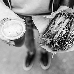 Image showing Female Hands Holding Delicious Organic Salmon Vegetarian Burger and Homebrewed IPA Beer.