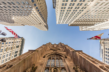 Image showing Wide angle upward view of Trinity Church at Broadway and Wall Street with surrounding skyscrapers, Lower Manhattan, New York City, USA