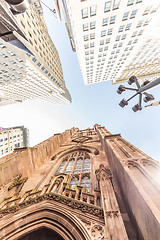 Image showing Wide angle upward view of Trinity Church at Broadway and Wall Street with surrounding skyscrapers, Lower Manhattan, New York City, USA